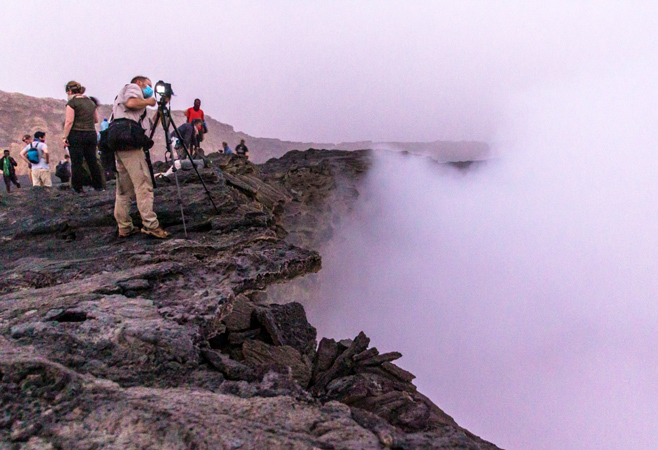 Tourists visit the black lava fields on the way to Erta Ale’s summit.